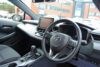 Front seats interior of a Toyota Corolla. Steering wheel and sat nav in view.