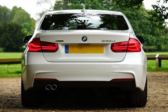 White BMW with the number plate not visible. Parked in front of a grassy area. Illegal number plate/ ghost plates.