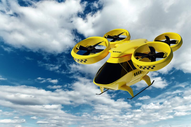 Concept image of an electric flying taxi against a background of blue skies with clouds