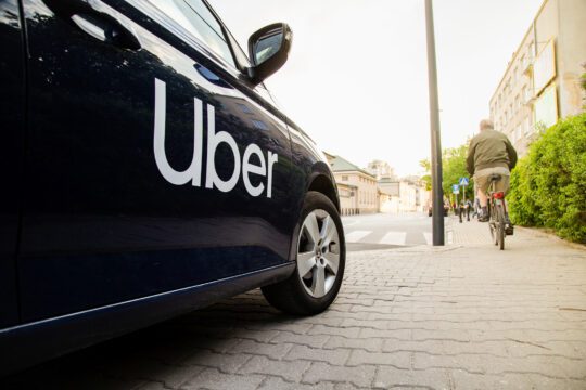 A private hire taxi vehicle that has an uber logo on its driver door