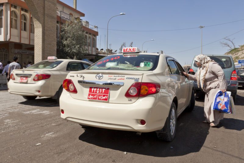 Female taxi customer negotiating with the taxi driver at Qalat street Erbil, Iraq.