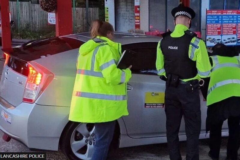 Police wearing hi-vis jackets talking to an uber driver. The car is behind them.