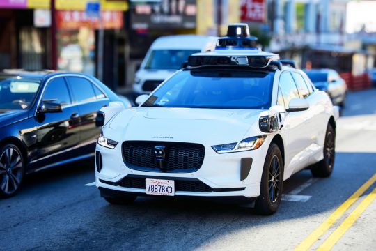 Waymo Jaguar driverless car on urban street. Front side view.